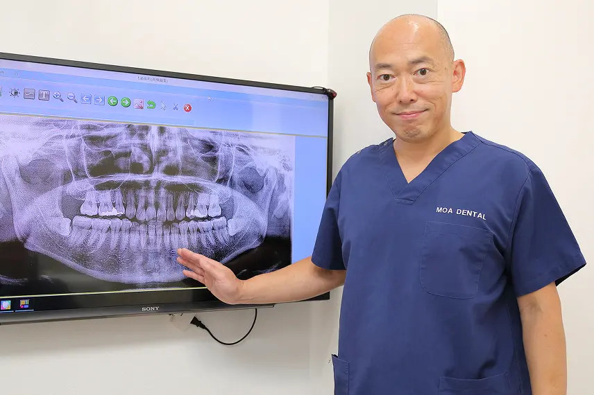 レントゲンを使用し患者と相談する院長