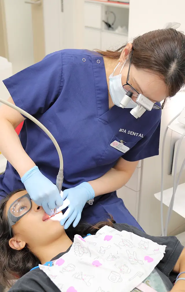 田中さやか副院長が子供の歯を治療している写真